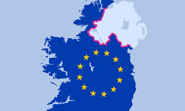 two men in building yard with hard hats, shaking hands